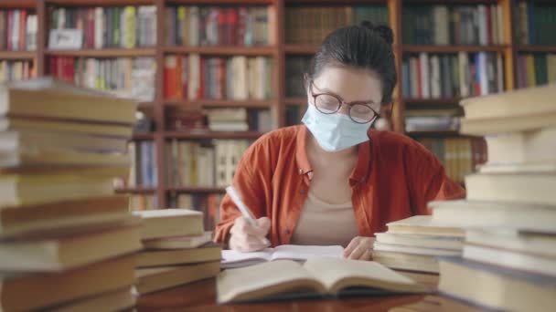 Mujer Asiática Máscara Facial Anotando Notas Libro Estudiando Durante Pandemia — Vídeo de stock