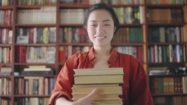Kütüphanede Kitap Tutan Gülümseyen Asyalı Kadın Araştırma Yapan Tıp Öğrencisi — Stok video
