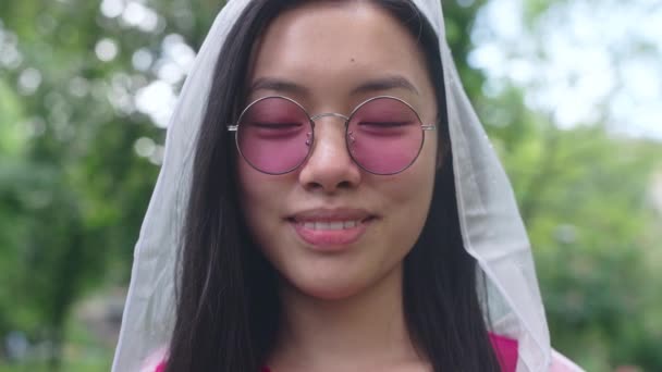 Stilvolle Asiatische Frau Mit Rosa Brille Und Regenmantel Lächelt Die — Stockvideo