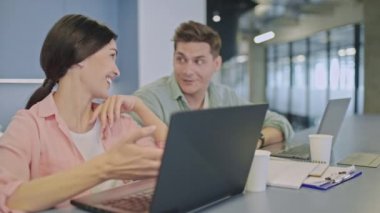 Pazarlama uzmanları proje detaylarını tartışıyor, ofiste konuşuyor, takım çalışması yapıyor.