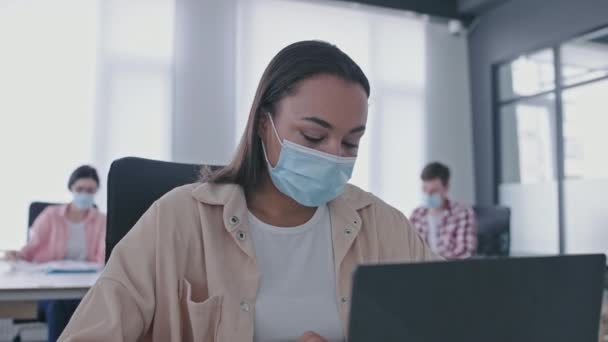 戴口罩 在笔记本电脑上打字 在办公室 医疗保健 病毒工作的女雇员 — 图库视频影像