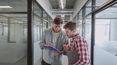 Genç ofis çalışanları ofiste proje tasarımı ve iş takım çalışmasını tartışıyor