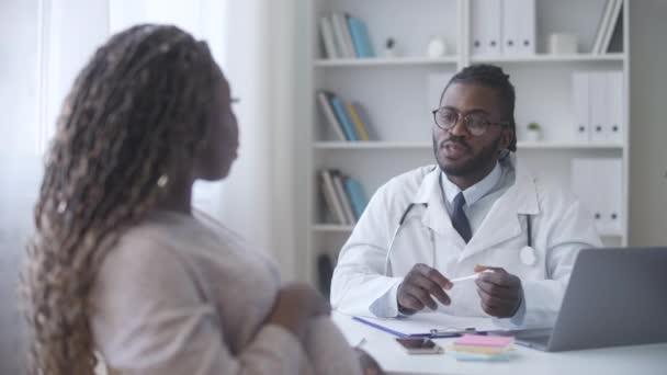 非洲裔美国男性产科医生为焦虑的孕妇提供咨询和检查 — 图库视频影像