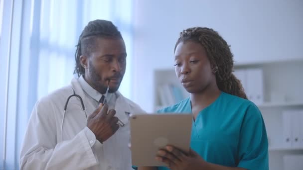 Sjuksköterska Diskuterar Patientens Sjukdomshistoria Med Läkare Med Hjälp Tablett Medicinsk — Stockvideo
