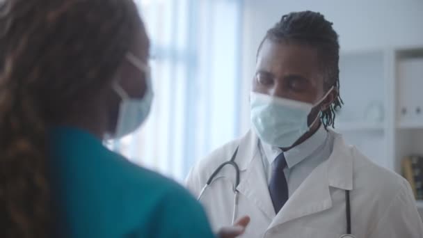 Black Doctor Medical Mask Talking Female Nurse Hospital Pandemic — Stock Video