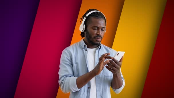 Młody Czarny Człowiek Pomocą Aplikacji Smartfon Korzystających Ulubionej Muzyki Słuchawkach — Wideo stockowe