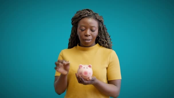 Молодая Африканская Женщина Кладет Монеты Копилку Планирует Бюджет Инвестиции — стоковое видео
