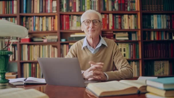 Retrato Hombre Mayor Amigable Que Trabaja Portátil Biblioteca Haciendo Investigación — Vídeos de Stock