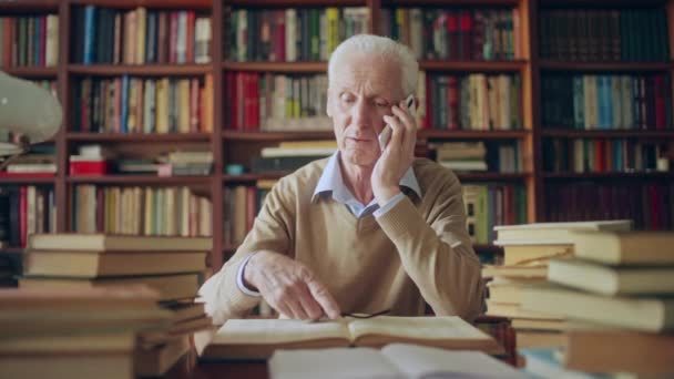 Starší Muž Vědec Dávat Rady Telefonu Odkazem Informace Knihách — Stock video