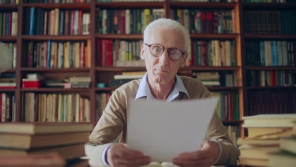 Professor Universitário Sênior Lendo Alunos Trabalhos Escritos Seu Escritório — Vídeo de Stock