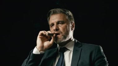 Zarif takım elbiseli, puro içen, yeni bir çeşidi tatan, tütün işi yapan kendine güvenen bir adam.