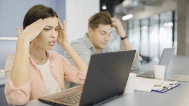 İki stresli ofis çalışanının projeyle ilgili sorunları var, teslim tarihine yetişemiyorlar.