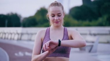 Genç kendine güvenen spor kadını spor bandına bakıyor, kalp hareketlerini izliyor.