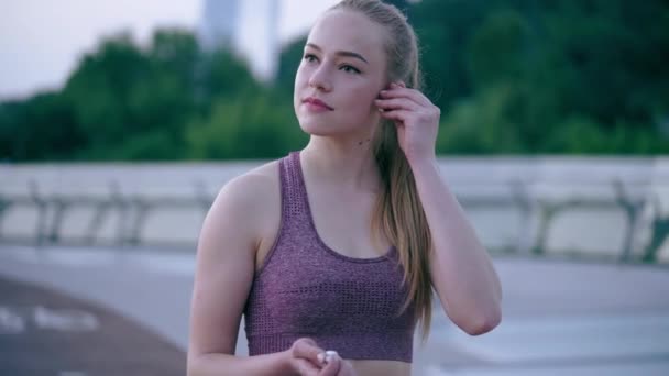 Mujer Joven Ropa Deportiva Poniéndose Auriculares Comenzando Entrenamiento Matutino — Vídeos de Stock