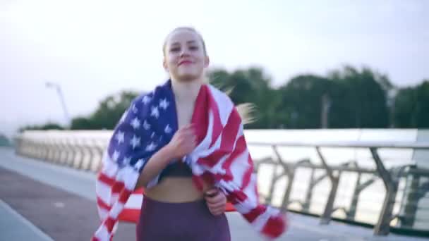 Trotse Jonge Vrouw Gewikkeld Usa Vlag Loopt Langs Brug Glimlachend — Stockvideo