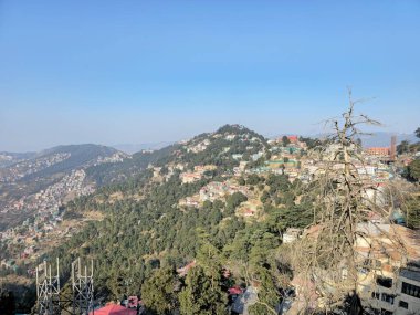 Yuvarlanan tepeler, dağınık evler ve orman örtüsü ile geniş vadi Shimla manzarası, yükseklik, doğal hatlar vurgulanıyor ve Himalaya manzara derinliği.