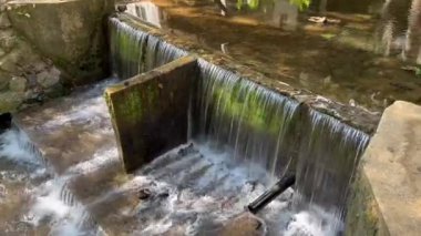 Kırsal kesimdeki bir nehirde akan su, su yönetimi, sulama sistemi, doğal akış, çevresel koruma ve kırsal kesimdeki sürdürülebilir altyapıyı gösteriyor.