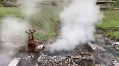 Paslı jeotermal boru doğal bir kaplıcada sıcak buhar salıyor, jeotermal enerjiyi temsil ediyor, yeraltı ısısını, basınç sistemini, Dünya 'nın doğal kaynaklarından yenilenebilir enerji üretimini,