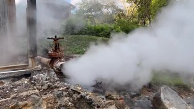 Paslı jeotermal boru doğal bir kaplıcada sıcak buhar salıyor, jeotermal enerjiyi temsil ediyor, yeraltı ısısını, basınç sistemini, Dünya 'nın doğal kaynaklarından yenilenebilir enerji üretimini,