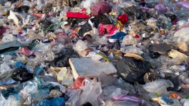 Plastik atık ve çöplerle dolu, yukarıdan gelen ciddi kirliliği gösteren, çevre krizini, aşırı tüketimi, sürdürülebilirlik sorunlarını ve doğa üzerindeki insan etkisinin altını çizen devasa çöp sahası
