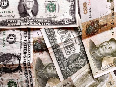 ABD doları ve Çin Yuan banknotları küresel finans, döviz, ekonomik rekabet, uluslararası ticaret, enflasyon baskısı ve dünya ekonomilerinin değişen dengesini sembolize ediyor