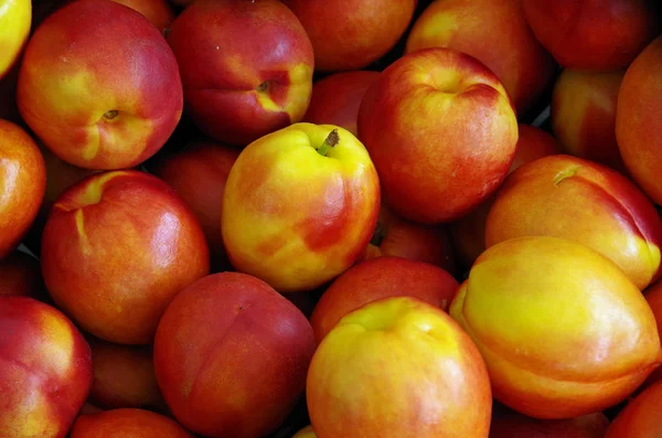 Çiftçi pazarına yakın çekim için sarı kırmızı nektarin görüntülemek