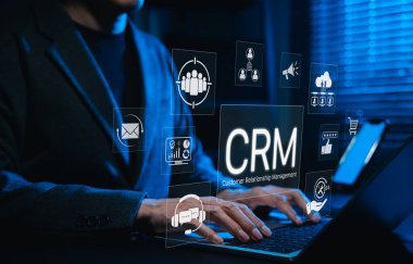 CRM sistemi ve müşteri ilişkileri yönetim teknolojisi. Müşteri ilişkileri yönetimini, pazarlama otomasyonunu, analitiği, müşteri ilişkileri araçlarını temsil eden dijital CRM simgeleriyle dizüstü bilgisayar kullanımı,