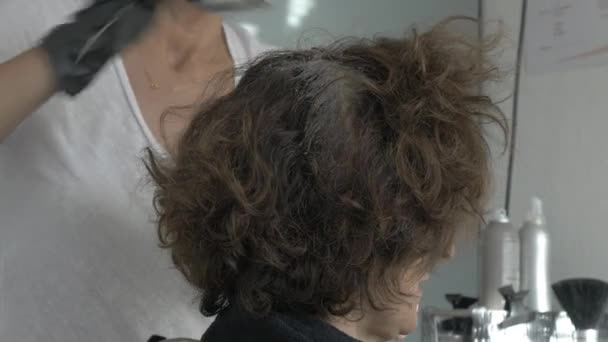Stylist hairdresser coloring hair roots — Stock Video