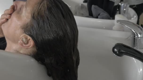 Estilista peluquero lavado de cabello en lavabo — Vídeo de stock