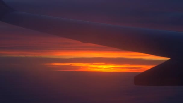 Flugzeugflügel mit Sonnenuntergang und Wolken — Stockvideo