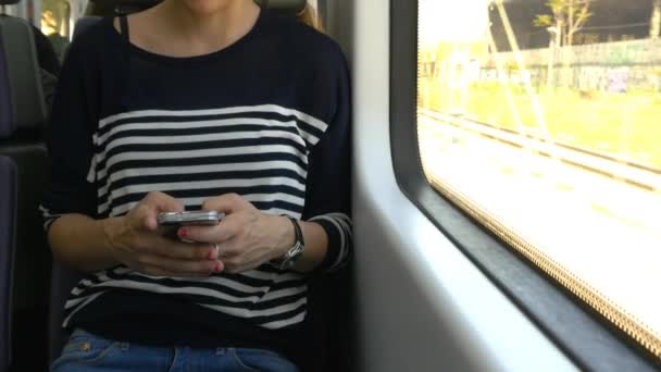 Женщина со смартфоном в поезде — стоковое видео