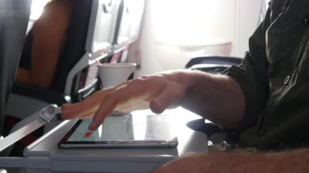 Человек с помощью планшета во время полета — стоковое видео