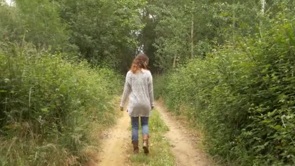 Vrouw wandelen in landelijke weg — Stockvideo