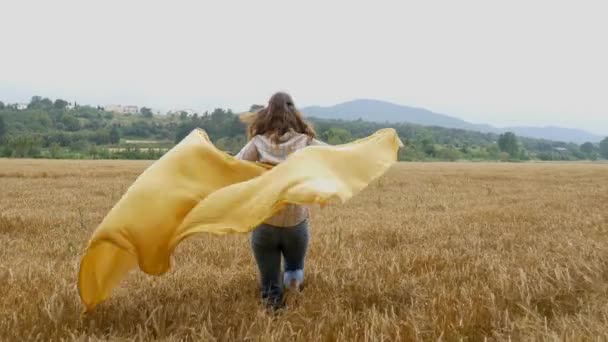 Жінка тримає жовтий шарф — стокове відео