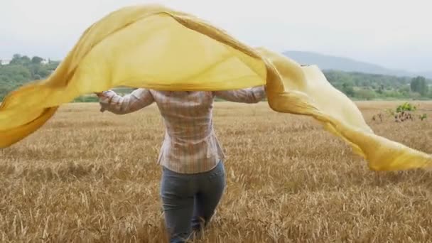 Vrouw bedrijf gele sjaal — Stockvideo