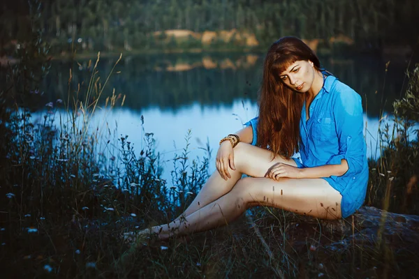 Mädchen sitzt mit nackten Füßen am See — Stockfoto