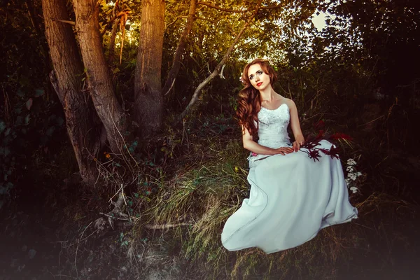 Menina em um vestido perto de uma árvore ao pôr do sol — Fotografia de Stock