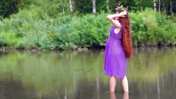 Беременная женщина у реки — стоковое видео