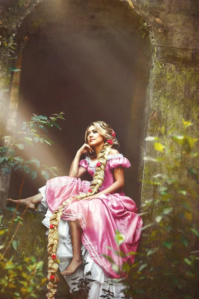Hermosa chica con el pelo largo trenzado en una trenza, en corsé y magnífico vestido rosa . — Foto de Stock
