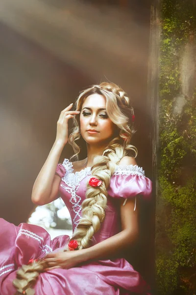 Hermosa chica con el pelo largo trenzado en una trenza, en corsé y magnífico vestido rosa . —  Fotos de Stock