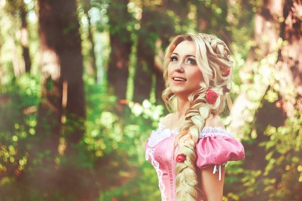 Krásná dívka s dlouhými vlasy sčesané do copu, v korzetu a nádherné růžové šaty. — Stock fotografie