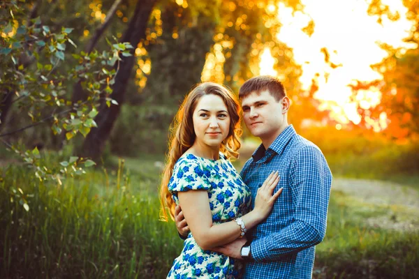 Pareja cariñosa abrazándose sentada en el bosque . — Foto de Stock