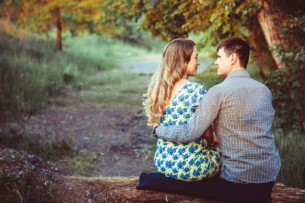 Loving couple embracing sitting in the woods. — Stock Photo, Image