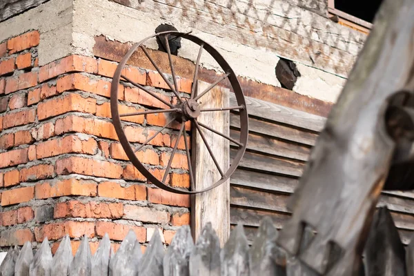 Een oud metalen wagenwiel staat bij het hek — Stockfoto