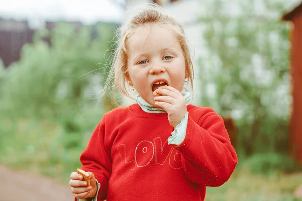 Uma Menina Casaco Vermelho Rua Comer Biscoitos — Fotografia de Stock