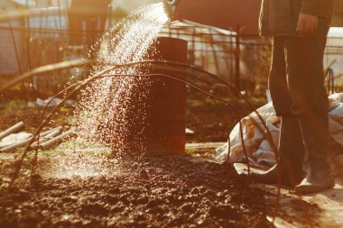 Bahçıvan, ülkesinin arazisindeki bir su bidonundan yatakları suluyor.