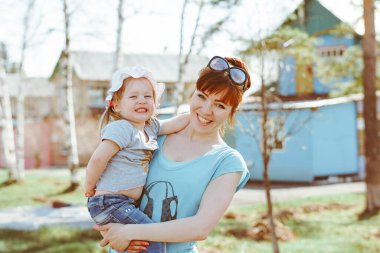 Anne bebeği kollarında tutuyor.