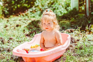 Mutlu bebek bahçede banyo yapıyor.