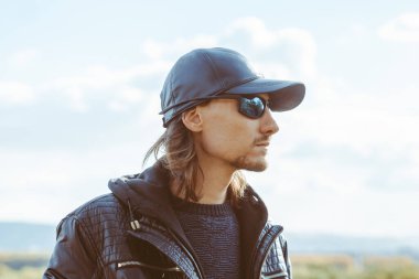 Bir sonbahar gününde mavi gökyüzüne karşı ceketli bir adam.