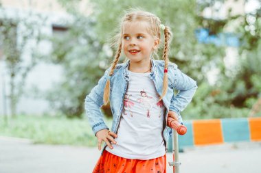 Parkta motosikletle gezen küçük kız.